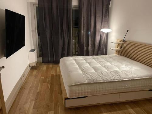 une chambre avec un lit blanc et une télévision dans l'établissement Le 7ème ciel, à Paris