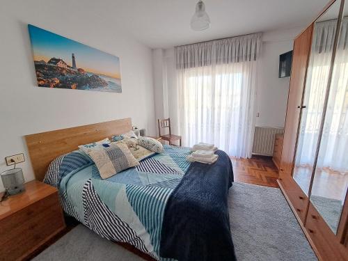 リバダビアにあるVivienda de uso turisticoのベッドルーム1室(ベッド1台、大きな窓付)