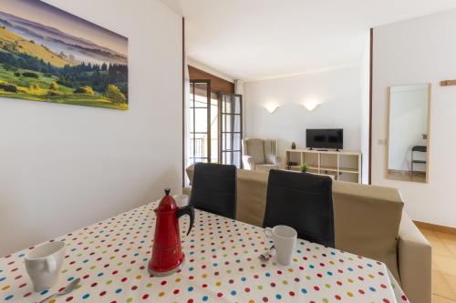 a dining room with a table with a red kettle on it at La Solana Apartaments & Spa in Encamp