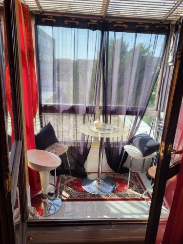 een kamer met een raam met een tafel en stoelen bij Studio de Luxe in Vitry-le-François