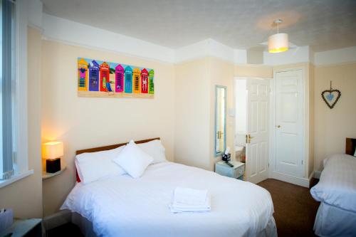 a bedroom with a white bed and a window at Sea Jade Guest House in Bude