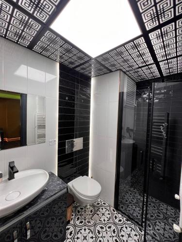 a bathroom with a toilet and a sink and a shower at Mono Life Suitten Jakuzili Daire in Mersin