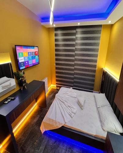 a bedroom with a bed and a desk and a tv at Mono Life Suitten Jakuzili Daire in Mersin