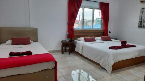 a bedroom with two beds and a window at Happy Beach Jomtien Guesthouse in Jomtien Beach