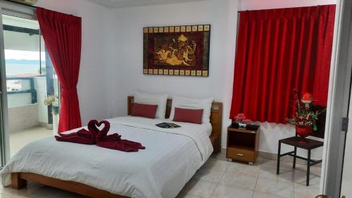 a bedroom with two beds with red drapes at Happy Beach Jomtien Guesthouse in Jomtien Beach