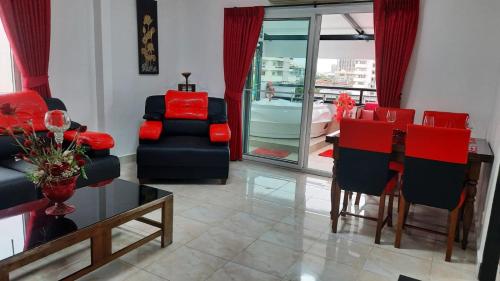 a living room with red and black chairs and a table at Happy Beach Jomtien Guesthouse in Jomtien Beach