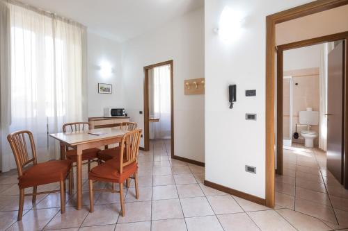 a dining room with a table and chairs and a bathroom at Residence XX Settembre in Alba