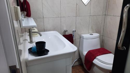 a bathroom with a white sink and a toilet at Happy Beach Jomtien Guesthouse in Jomtien Beach