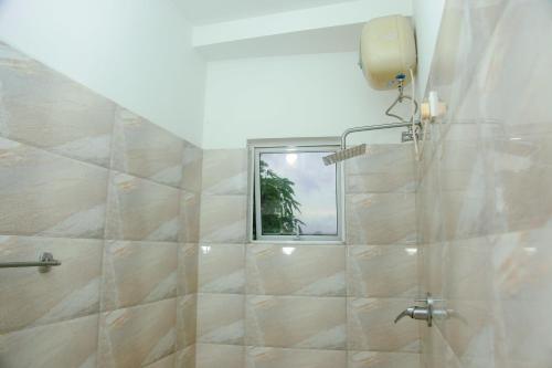 Un baño con ducha con ventana. en Kadolana Villa, en Mirissa
