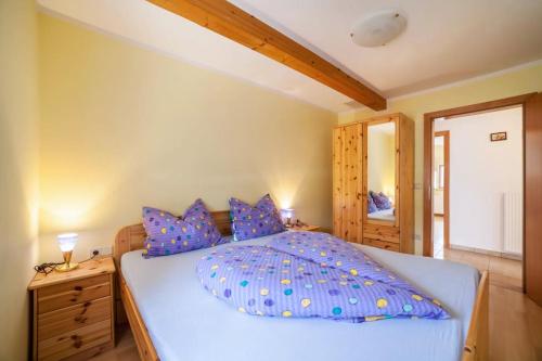 a bedroom with a large bed with blue pillows at Oberkapillhof in Meltina