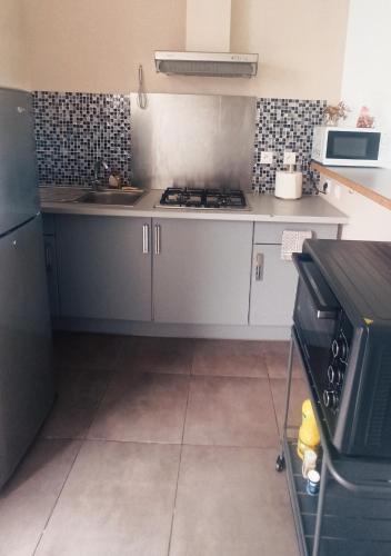 a kitchen with a sink and a stove top oven at La Caz'Anna 2 in Cilaos
