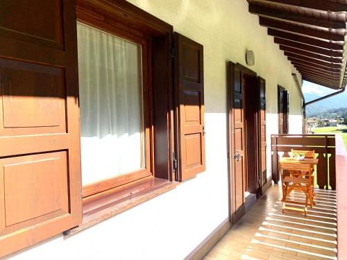 a house with doors and a table on the porch at Cima de' Piazzi Apartment 2 in Isolaccia