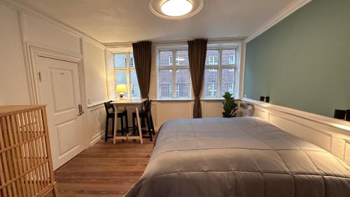 a bedroom with a bed and a table and a window at Boutique Apartments 1 - 8 in Copenhagen