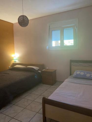 1 dormitorio con 2 camas y ventana en Seaside Blue Coast Apartment, en Anavyssos