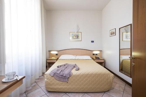 1 dormitorio con 1 cama con albornoz en Residence XX Settembre en Alba