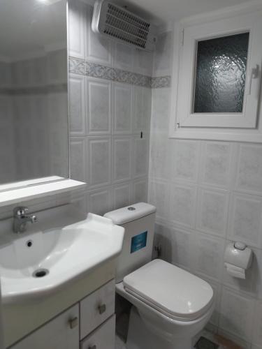 een witte badkamer met een toilet en een wastafel bij AniBo studios and apartments ZERO POINT 46 in Thessaloniki