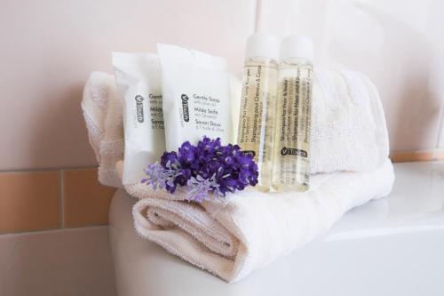 łazienka z ręcznikami i kwiatami na ladzie w obiekcie Residence XX Settembre w Albie