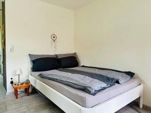 uma cama num quarto com uma parede branca em ☆Gemütliche 1-Zimmerwohnung mit Terrasse☆ 