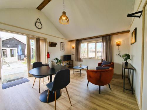 a living room with a table and chairs at 2-persoons luxe vakantiewoning in De Veenhoop