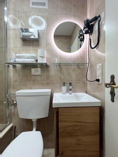 a bathroom with a toilet and a sink and a mirror at Sieben Zimmer am See in Prien am Chiemsee