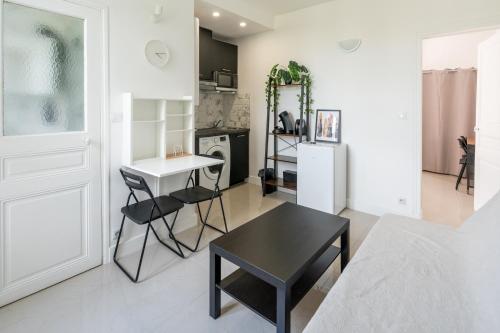 sala de estar con mesa y cocina en Cozy & modern flat next to M12 Front Populaire en Saint-Denis