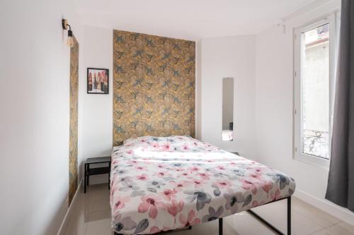 1 dormitorio con 1 cama con manta de flores en Cozy & modern flat next to M12 Front Populaire en Saint-Denis