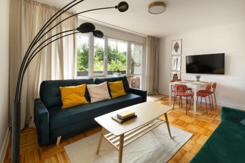 a living room with a blue couch and a table at Zakątek Kudowa Rodzinny in Kudowa-Zdrój