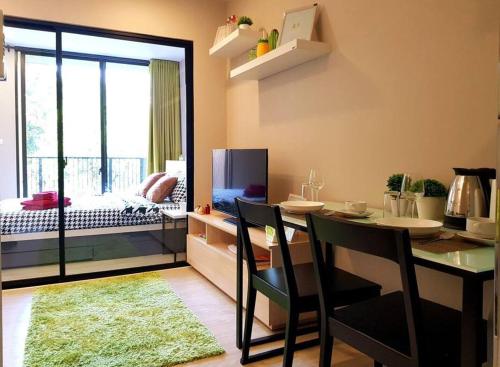 a living room with a dining table and a bedroom at Nimman Soi 5, Chiang Mai in Chiang Mai