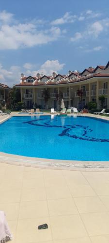 een groot blauw zwembad voor een gebouw bij Sea Villa Apart in Fethiye