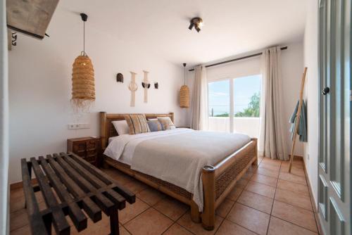 a bedroom with a bed and a bench and a window at Private Villa near Ibiza town (10min) in Sant Josep de Sa Talaia