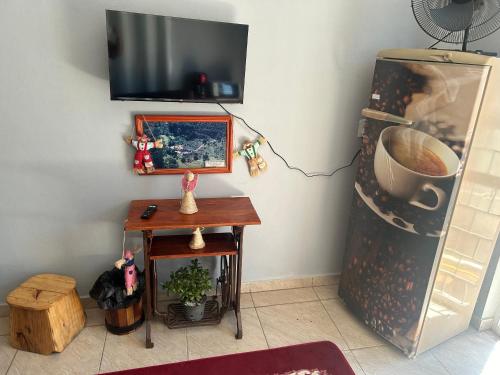 een kamer met een oven, een tafel en een televisie bij Kit net flor de café in Caparaó Velho