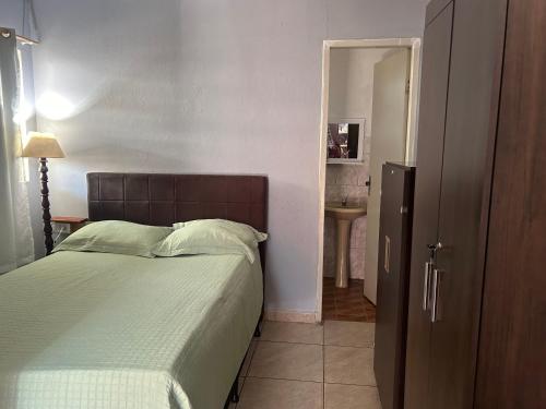 a bedroom with a bed and a door to a bathroom at Kit net flor de café in Alto Caparao