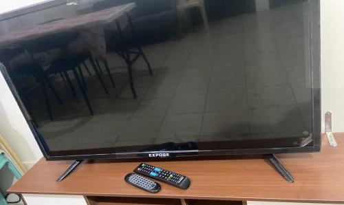 a television with two remote controls sitting on a table at Blessed Condo for 6 - include net, water & electric in Manila