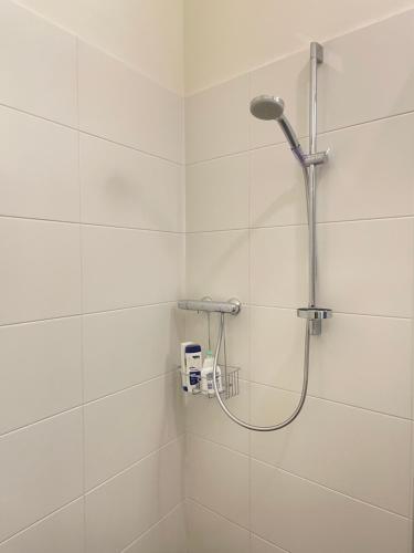 La salle de bains est pourvue d'une douche et de carrelage blanc. dans l'établissement Apartment St Stephens Cathedral, à Vienne