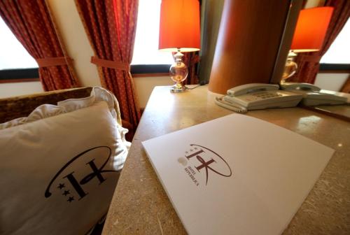 a table with a phone and a sign on it at HR Hotel in Monfalcone