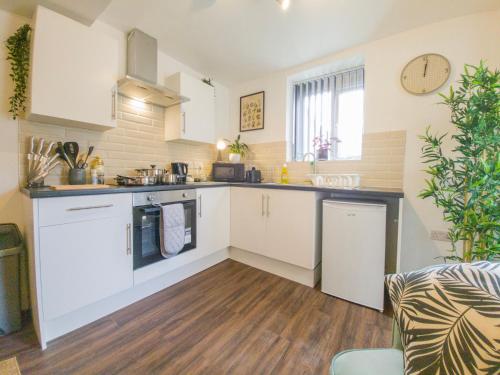 a kitchen with white cabinets and a counter top at Principality Suites - Two Bed Apartment by Property Promise in Cardiff