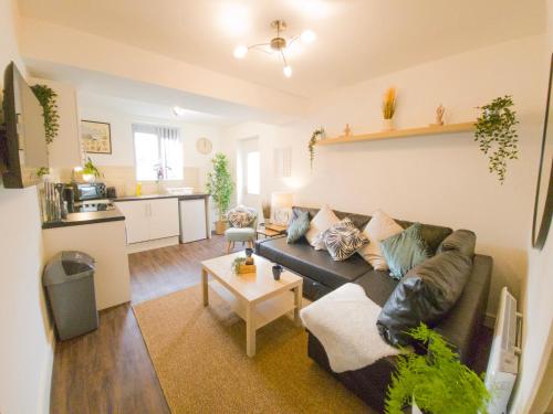 a living room with a couch and a kitchen at Principality Suites - Two Bed Apartment by Property Promise in Cardiff