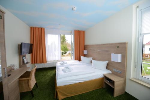 GrünbachにあるDer Bayerische Hofのベッド、デスク、窓が備わるホテルルームです。