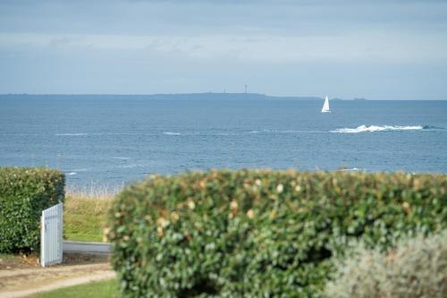 a sail boat in the ocean with a boat in the water at STERENN VOR - Appartement vue mer in Lampaul-Plouarzel