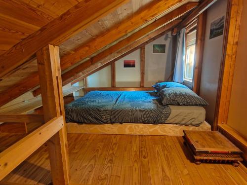 a bed in the attic of a cabin at Belle maison Vue imprenable lac de Serre-Ponçon in Prunières