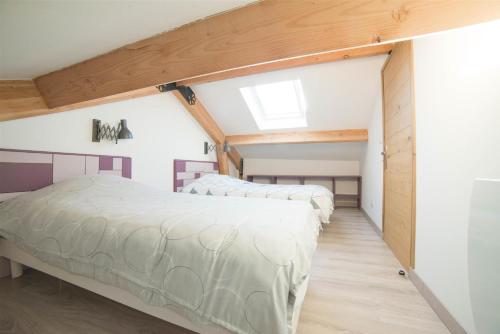 a bedroom with two beds and a skylight at Le Carport in Hasnon