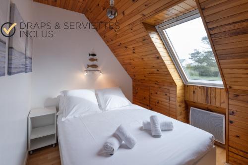 a bedroom with a white bed with towels on it at STERENN VOR - Appartement vue mer in Lampaul-Plouarzel