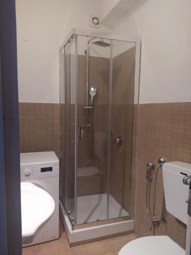 a shower in a bathroom with a toilet and a sink at Casa Latiini 1-2 in Pontinia