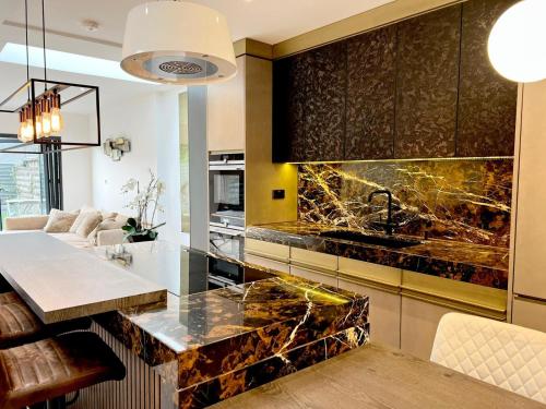 a kitchen with a granite counter top and a table at Luxury Architect Designed Town House Near Beach in Littlehampton