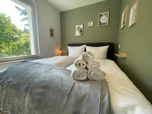 a bedroom with two beds with towels on them at Vorstadtoase - 3 Personen - Apartment mit Queensize-Bett, Badewanne, Schlafcouch, Parken, Netflix, Nähe BER in Eichwalde