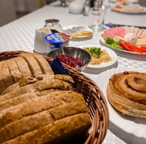 a table with a basket of bread and plates of food at Ośrodek Tulipan in Ustroń