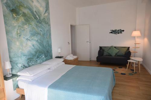 a bedroom with a large bed and a couch at Casa VerdeMare in Lido di Ostia