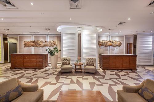 a lobby with couches and tables in a building at THE 1O1 Bogor Suryakancana in Bogor