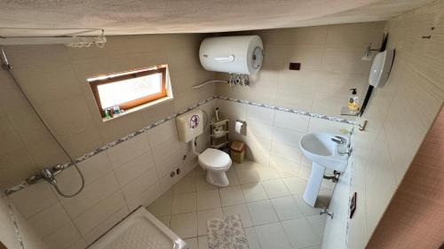 a small bathroom with a toilet and a sink at Vila Deda Tale in Lezhë