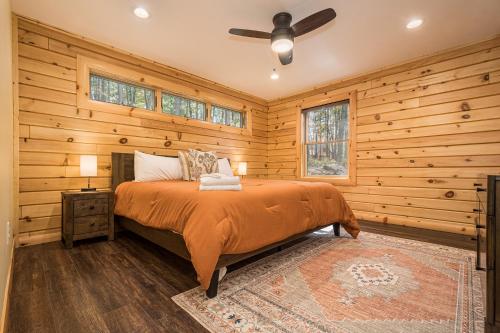 a bedroom with a bed in a room with wooden walls at Moon and Stars in McHenry